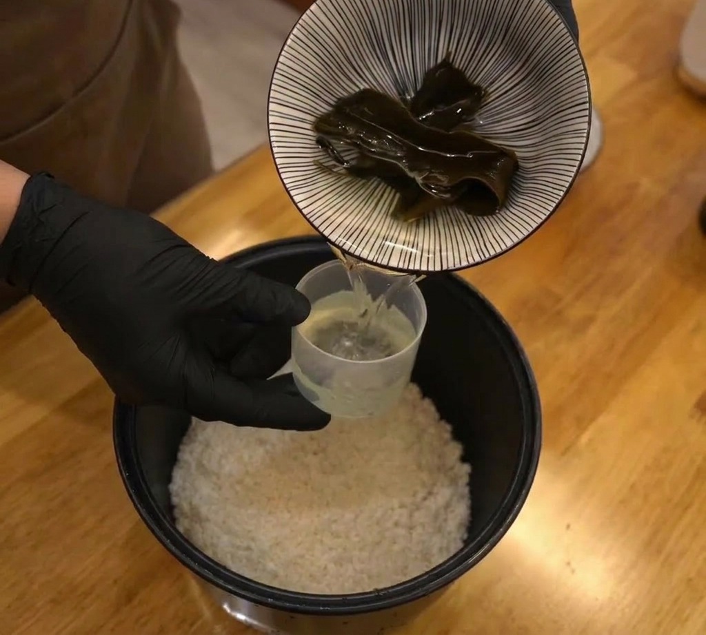 炊飯器のお米の上に乾燥昆布を乗せる様子
