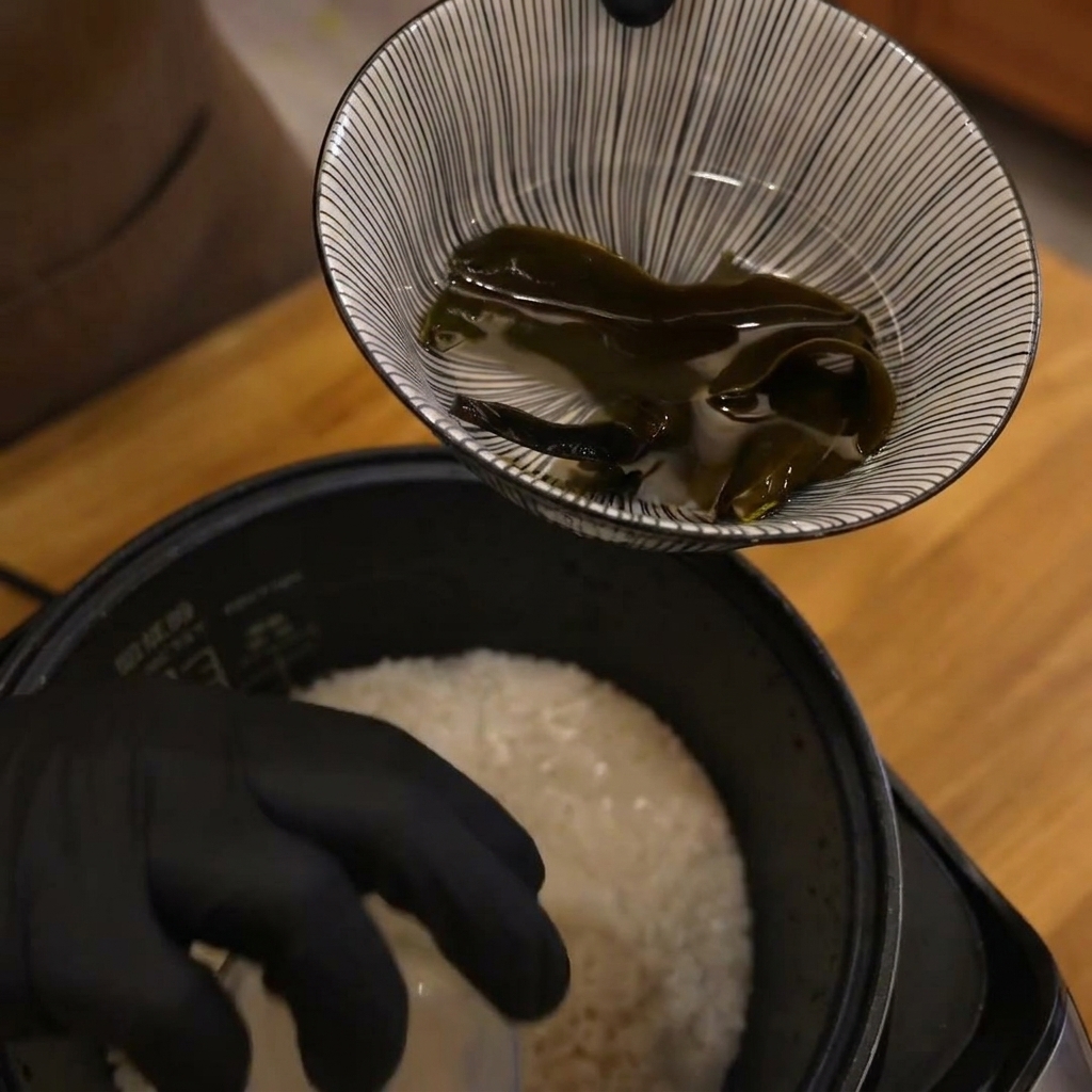 炊飯器の中で水に浸かっているお米と昆布