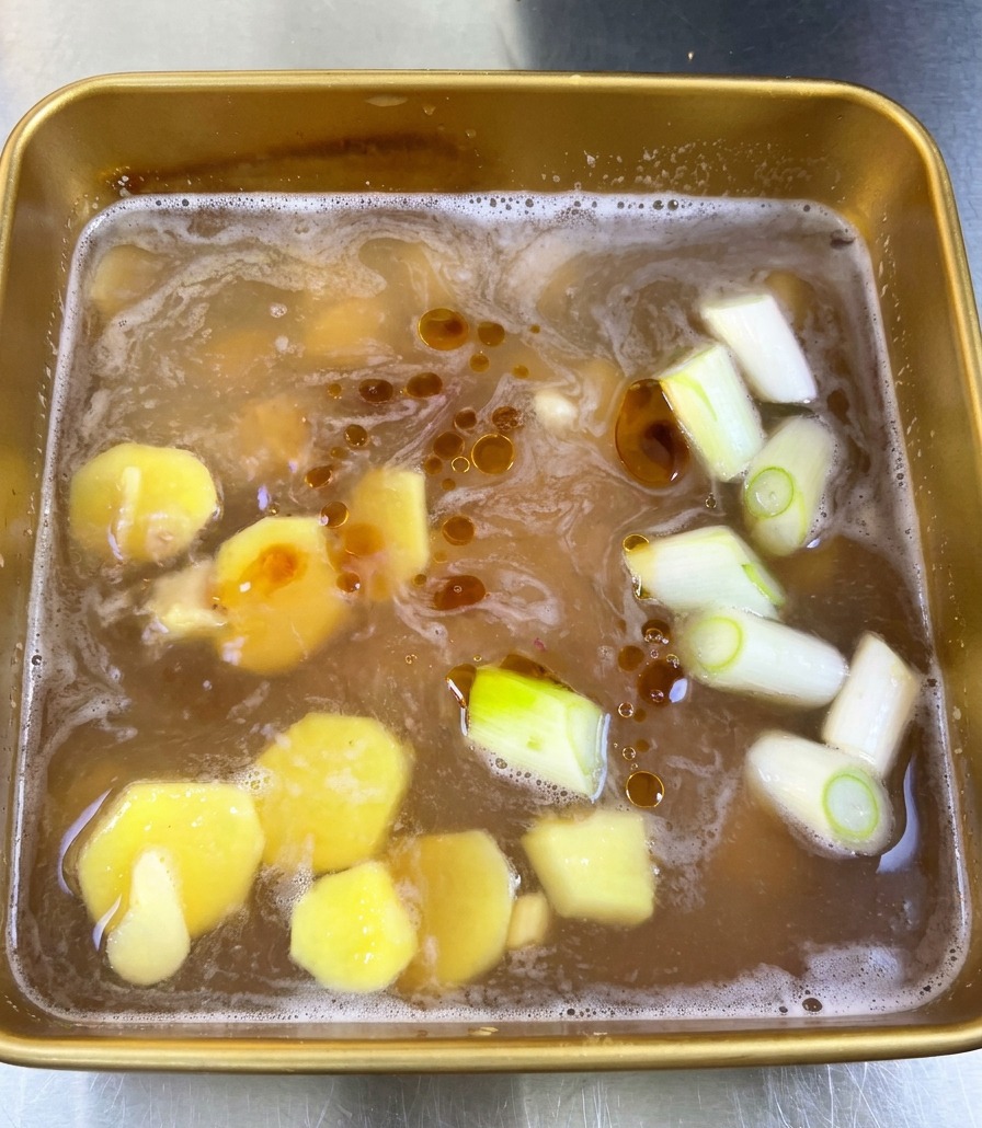 タレの表面に、黄金色のごま油が油紋のように浮かんでいる様子。