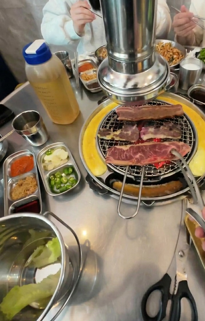 炭火で焼いている肉をひっくり返したところ。表面には美味しそうな焼き色がつき、脂が浮き出ている。
