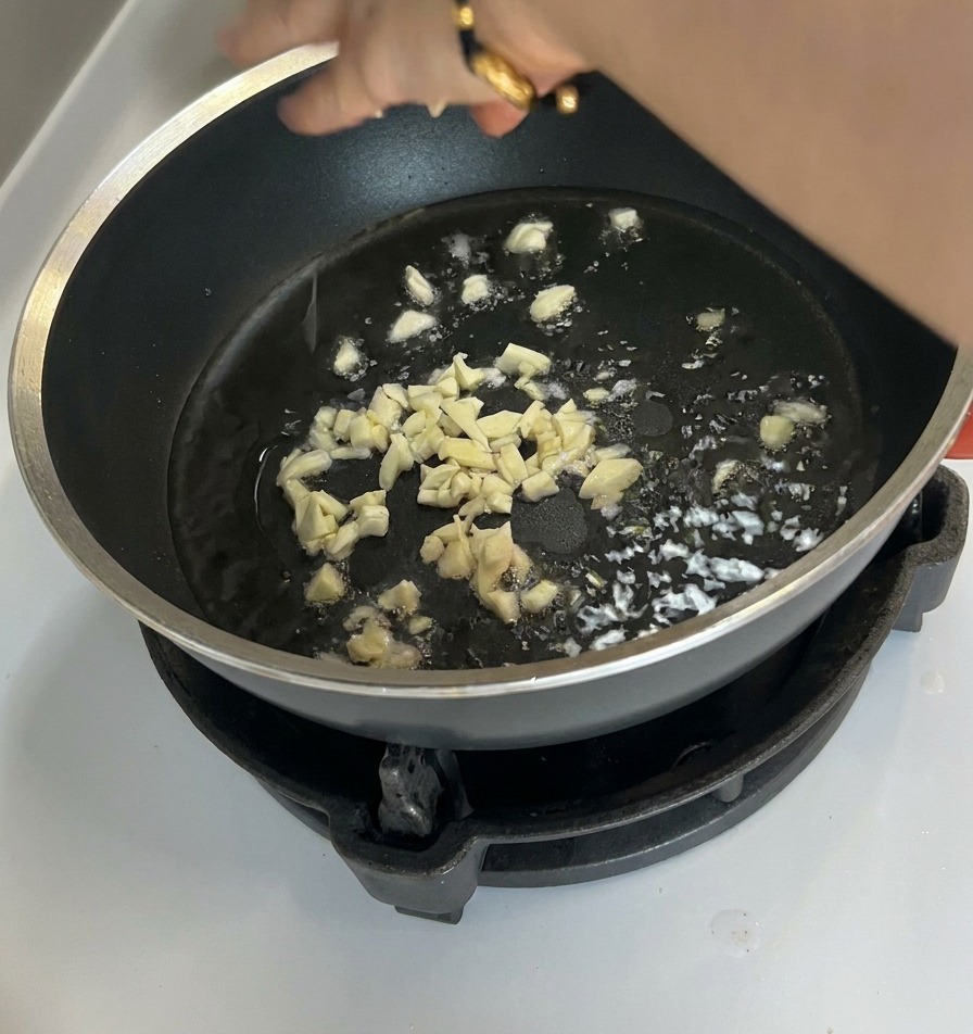 フライパンで刻みにんにくを熱し、香りを引き出している様子。