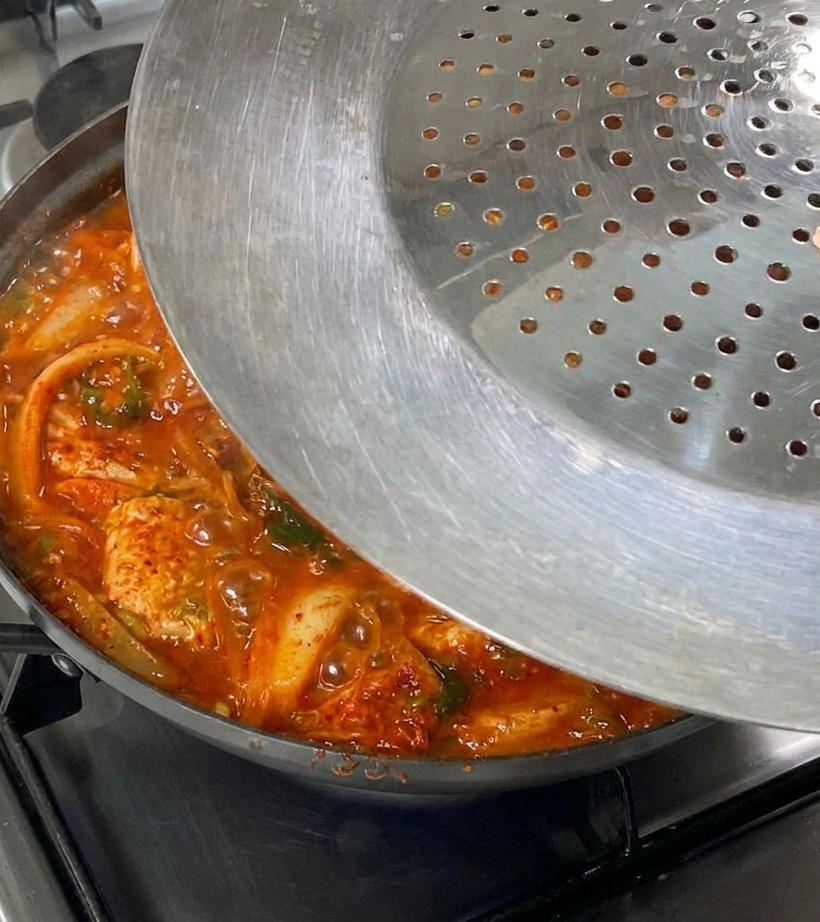 コンロの上で蓋をした鍋がコトコトと煮えている様子。