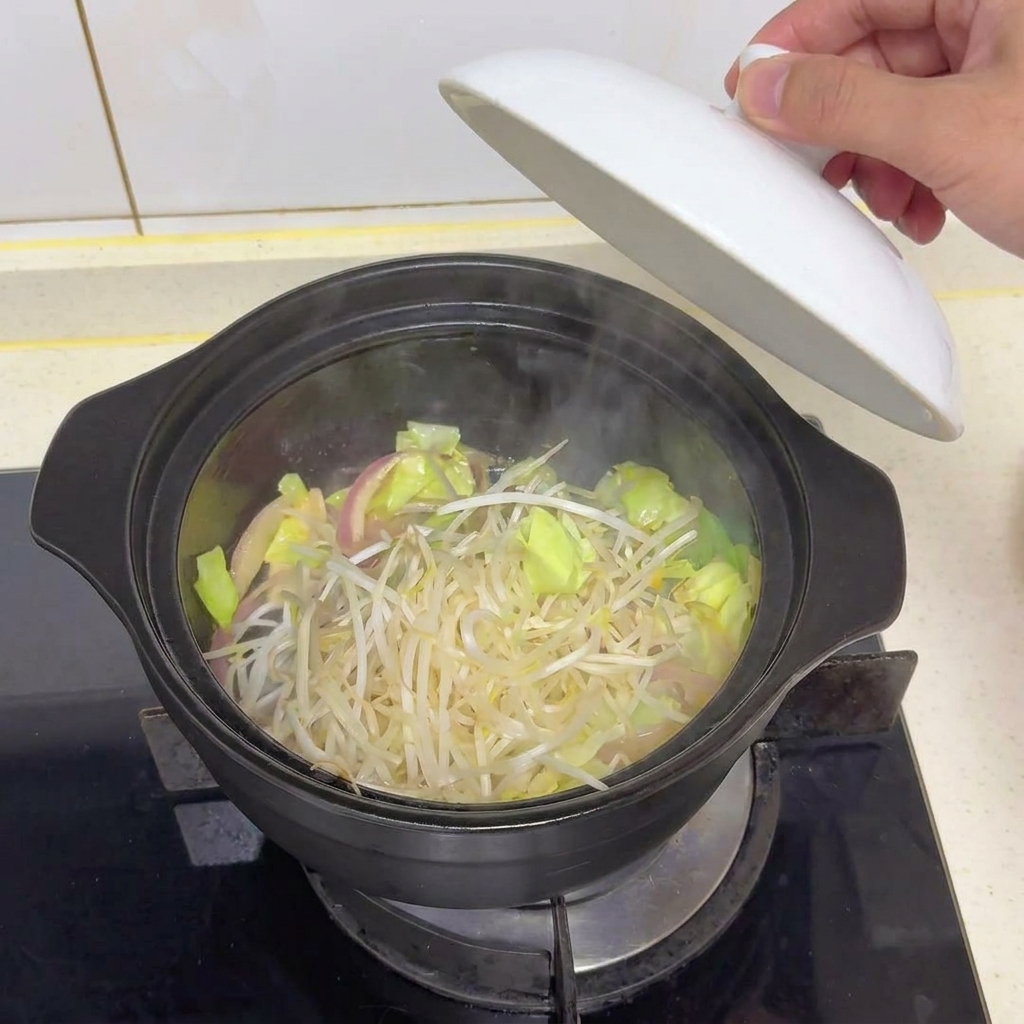 鍋の中の野菜の上に、新鮮なもやしを一掴み加えている様子。
