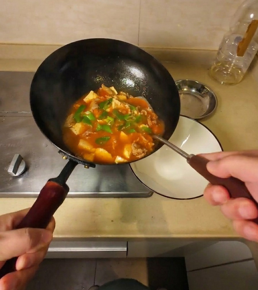 完成した具だくさんのスープを、鍋から白い器に丁寧に盛り付けている様子。