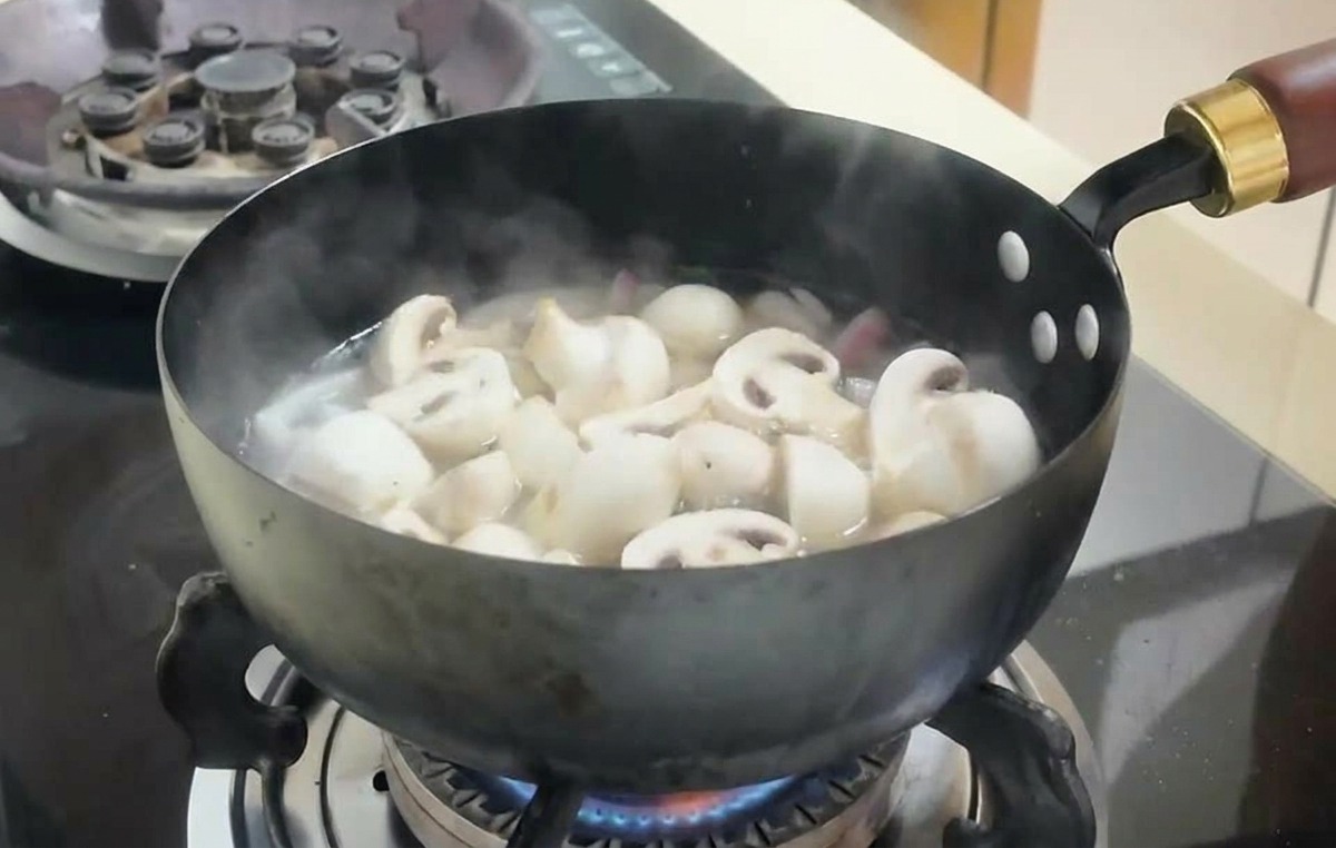 沸騰したスープの中でマッシュルームと豆腐が煮込まれている様子。