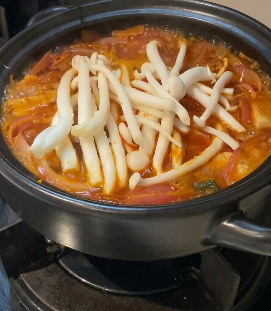 赤いスープの上に、白いしめじをたっぷりとのせている様子。