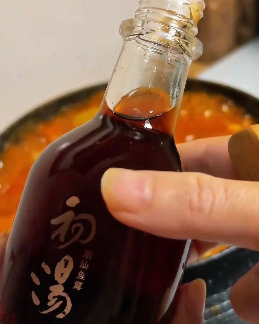 沸騰している鍋に魚醤を回し入れている様子。