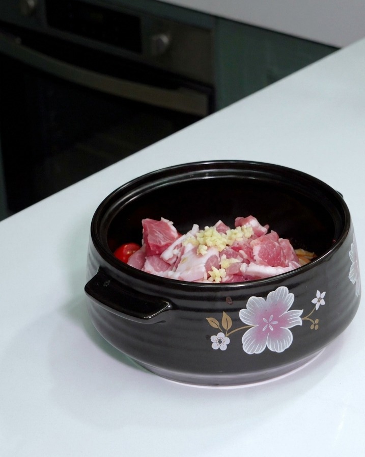 鍋の中の肉や野菜の上に、おろしにんにくを乗せた様子