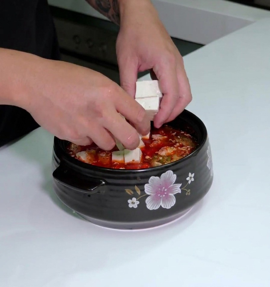 スープの上に白い豆腐と長ねぎを綺麗に並べて配置した様子