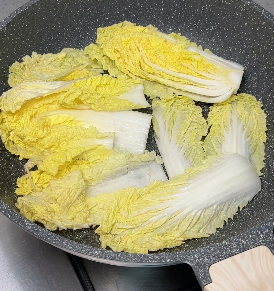 浅めの鍋の底に、ざく切りにした白菜を敷き詰めている様子