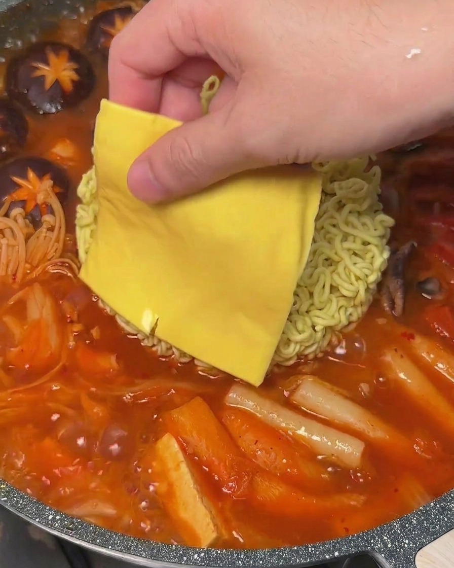 ラーメンの上にスライスチーズをのせ、スープの熱で溶け始めている様子