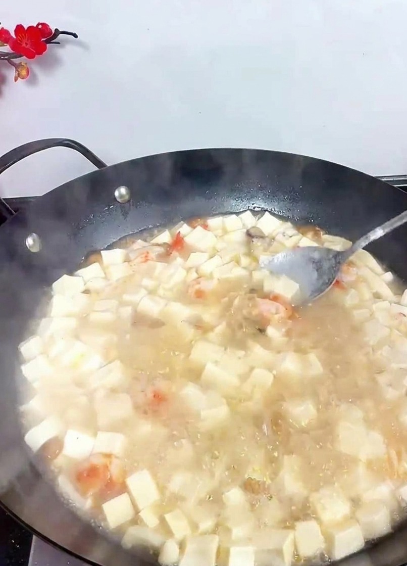 スープをスプーンで優しく混ぜ、調味料をなじませている様子。