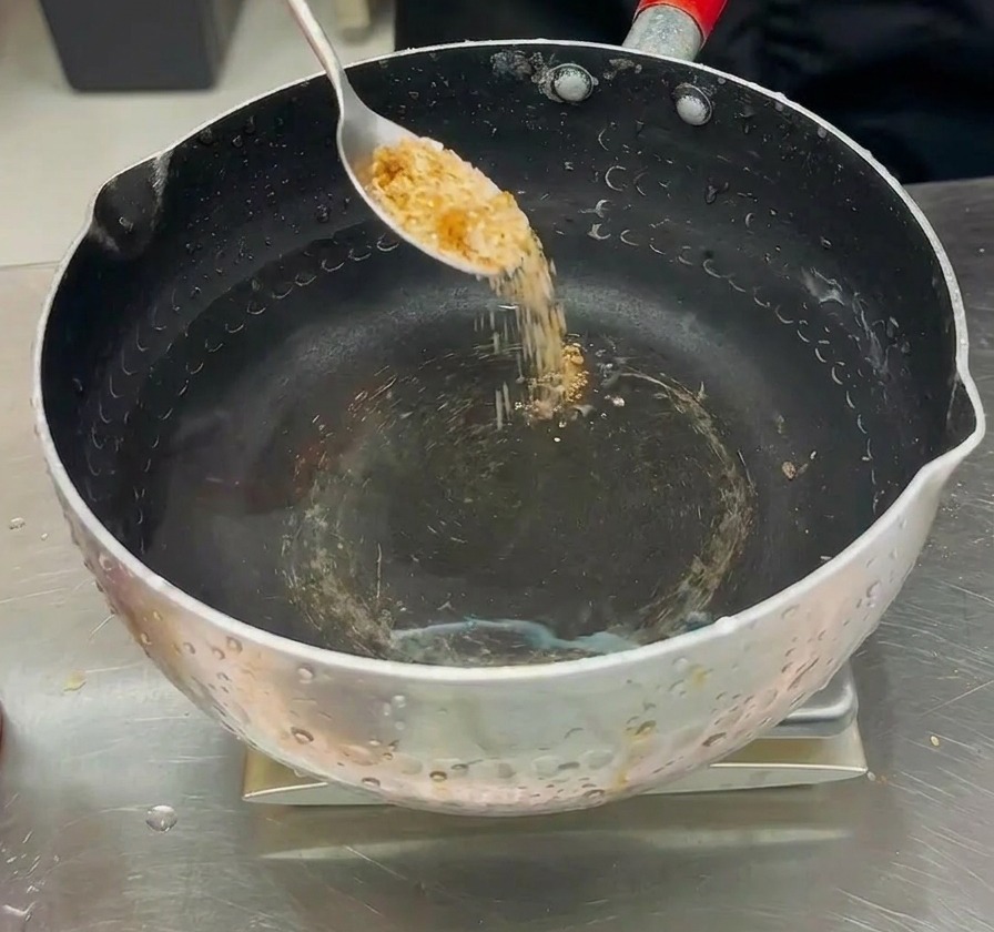 鍋に入った水に、調合した粉末だしを加えてスープを作っている様子。