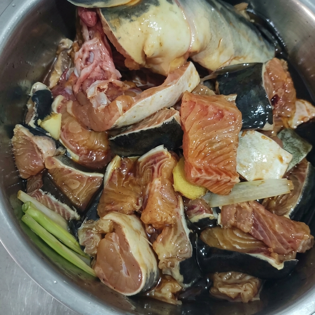 生姜、ネギ、調味料と和えられたナマズの切り身。