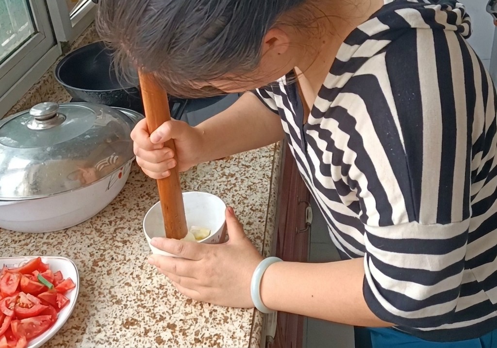 すり鉢とにんにくを使って、にんにくをペースト状にする様子