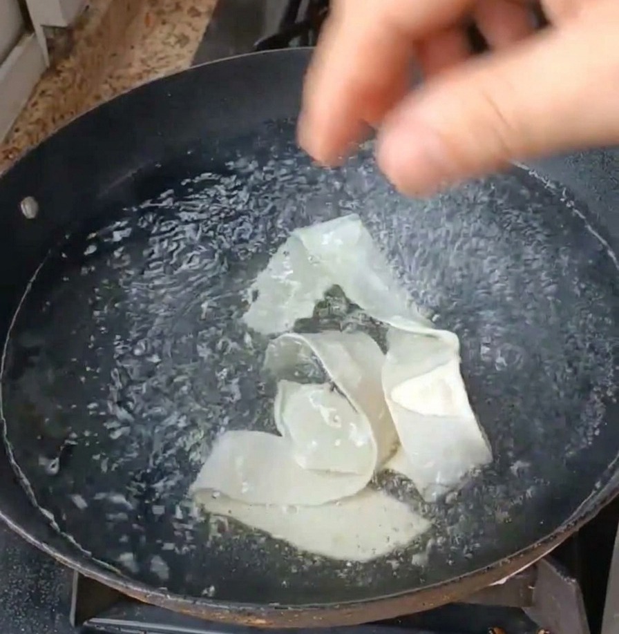 沸騰したお湯に幅広麺とレタスを投入する様子