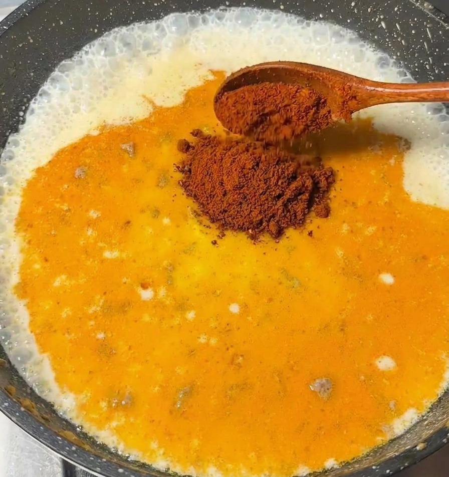 泡立つミルクベースのスープに、カレールーを割り入れている場面。