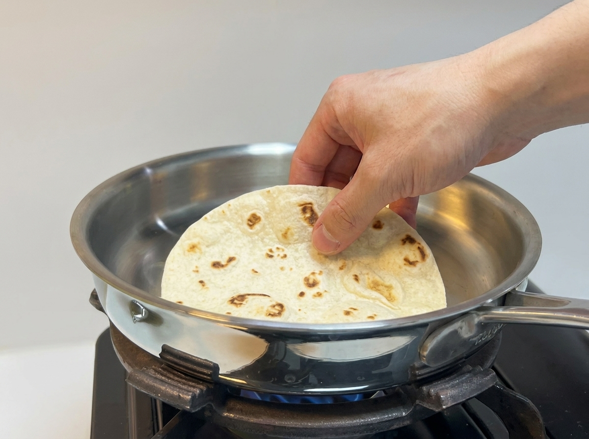 ステンレスパンの上で厚手のトルティーヤを温めている様子。