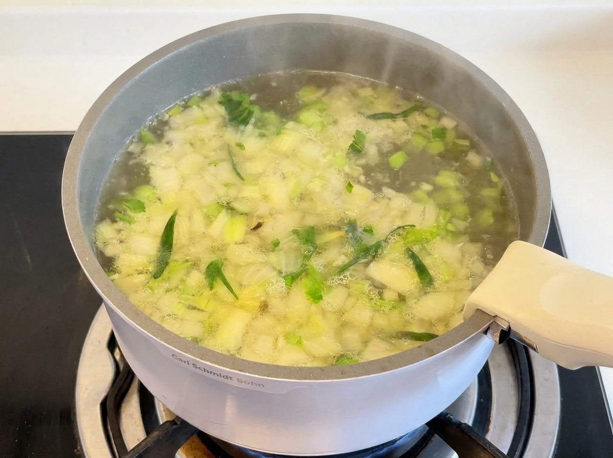 グツグツと煮立つスープの中で、鶏もも肉とお米が煮込まれている様子。