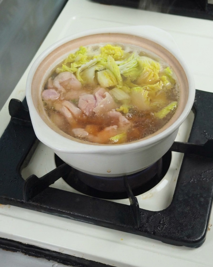 スープに醤油を回し入れ、味を調えている様子。