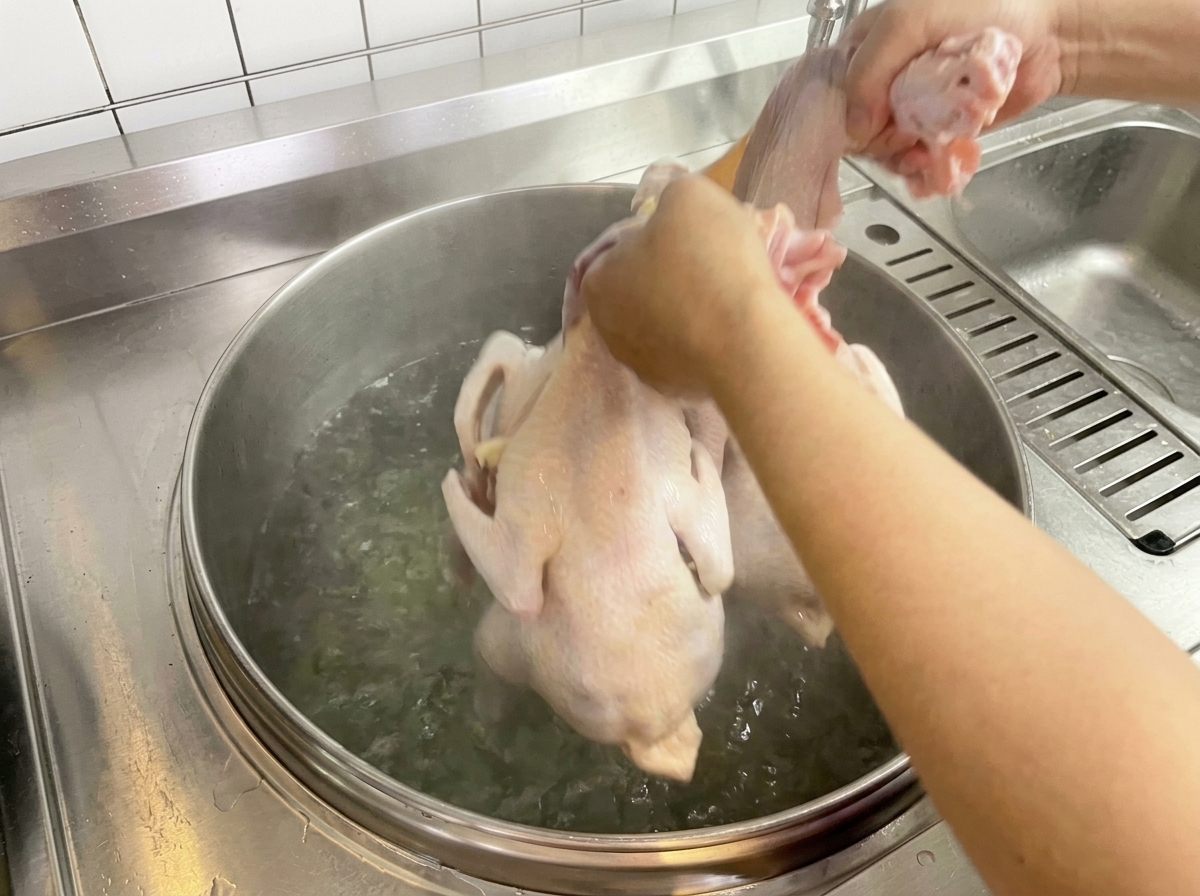 沸騰した鍋に鶏肉を入れている様子