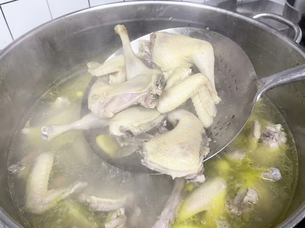 網杓子で鶏肉をすくい上げている様子