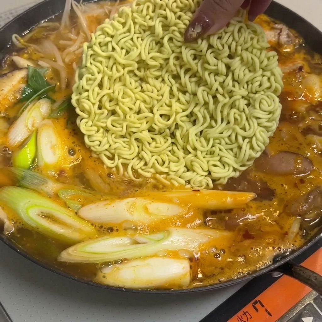 スープにラーメンとトッポギが入っている。