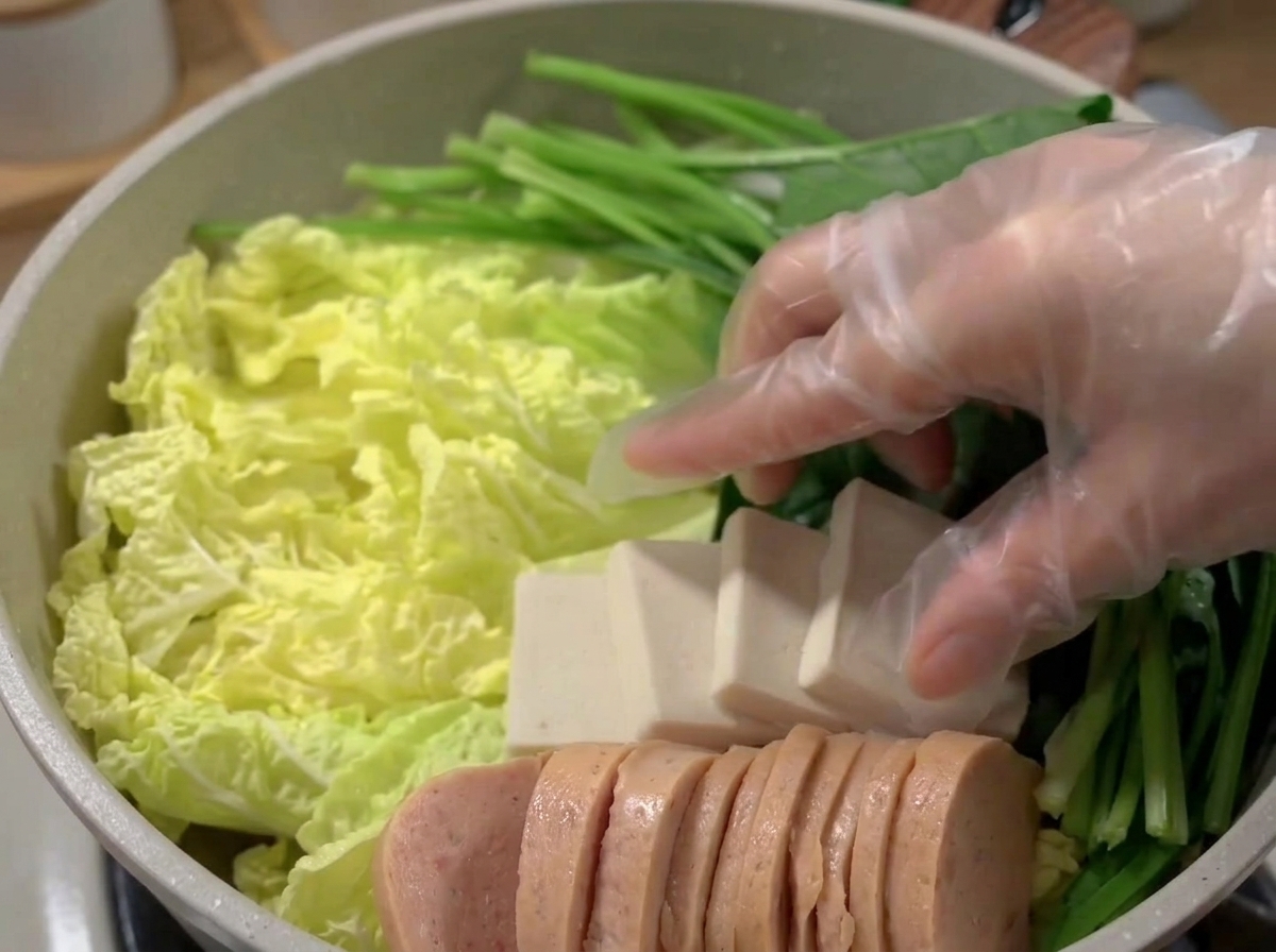 ランチョンミート、豆腐、さつま揚げ、野菜が綺麗に盛り付けられた鍋。