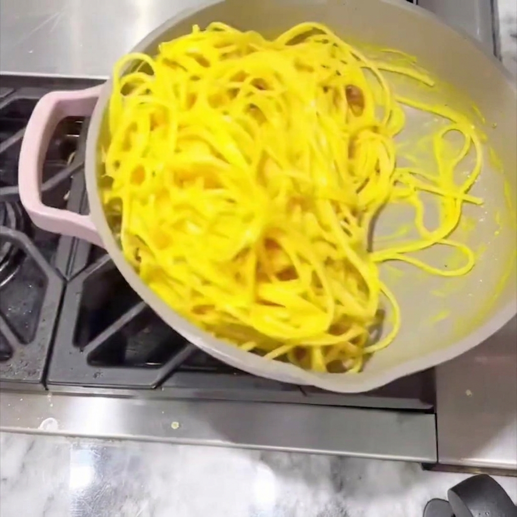 ソースが絡んだパスタを混ぜ合わせる様子。
