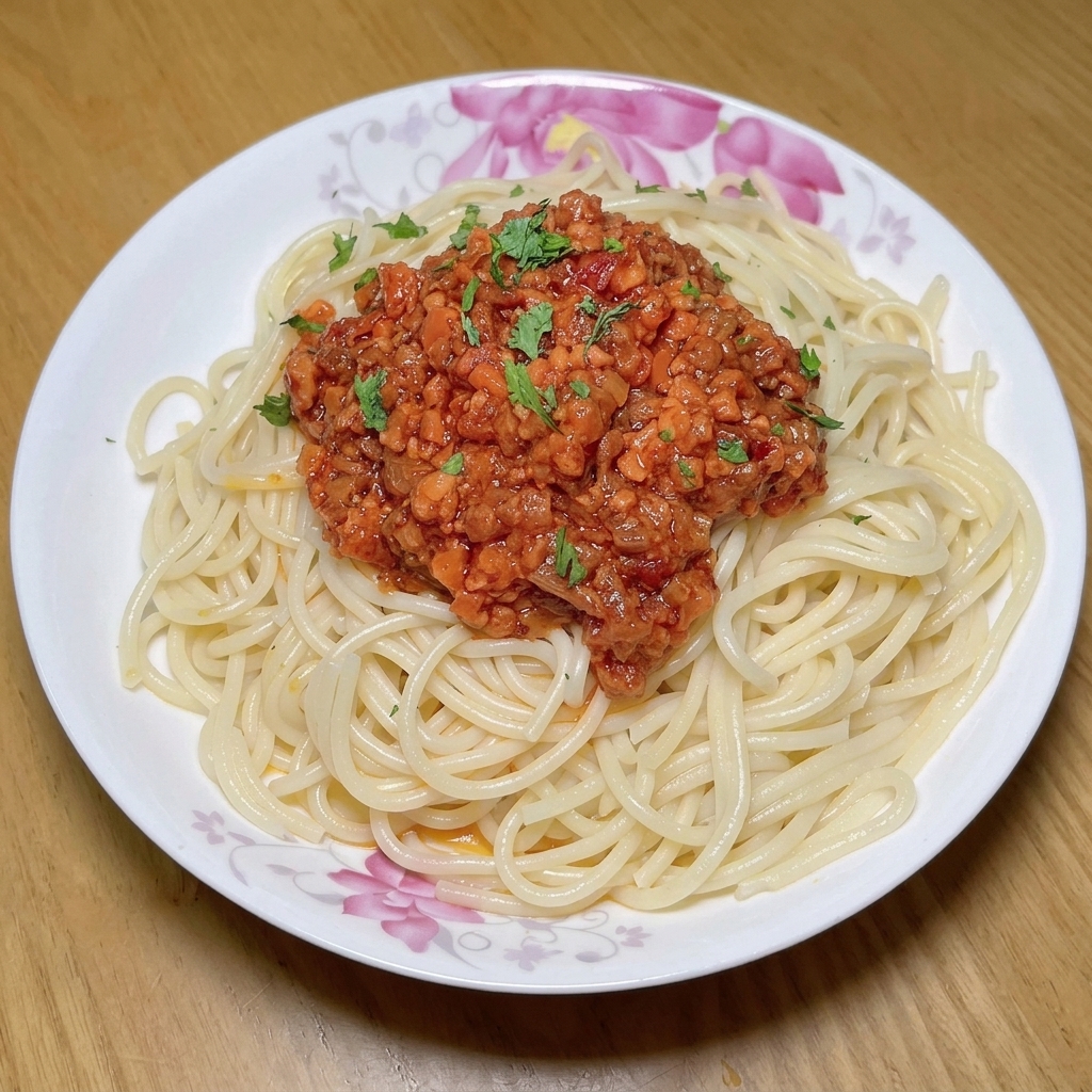 お肉、野菜、トマトペーストが入ったフライパンに、新鮮な角切りトマトを加えている様子。