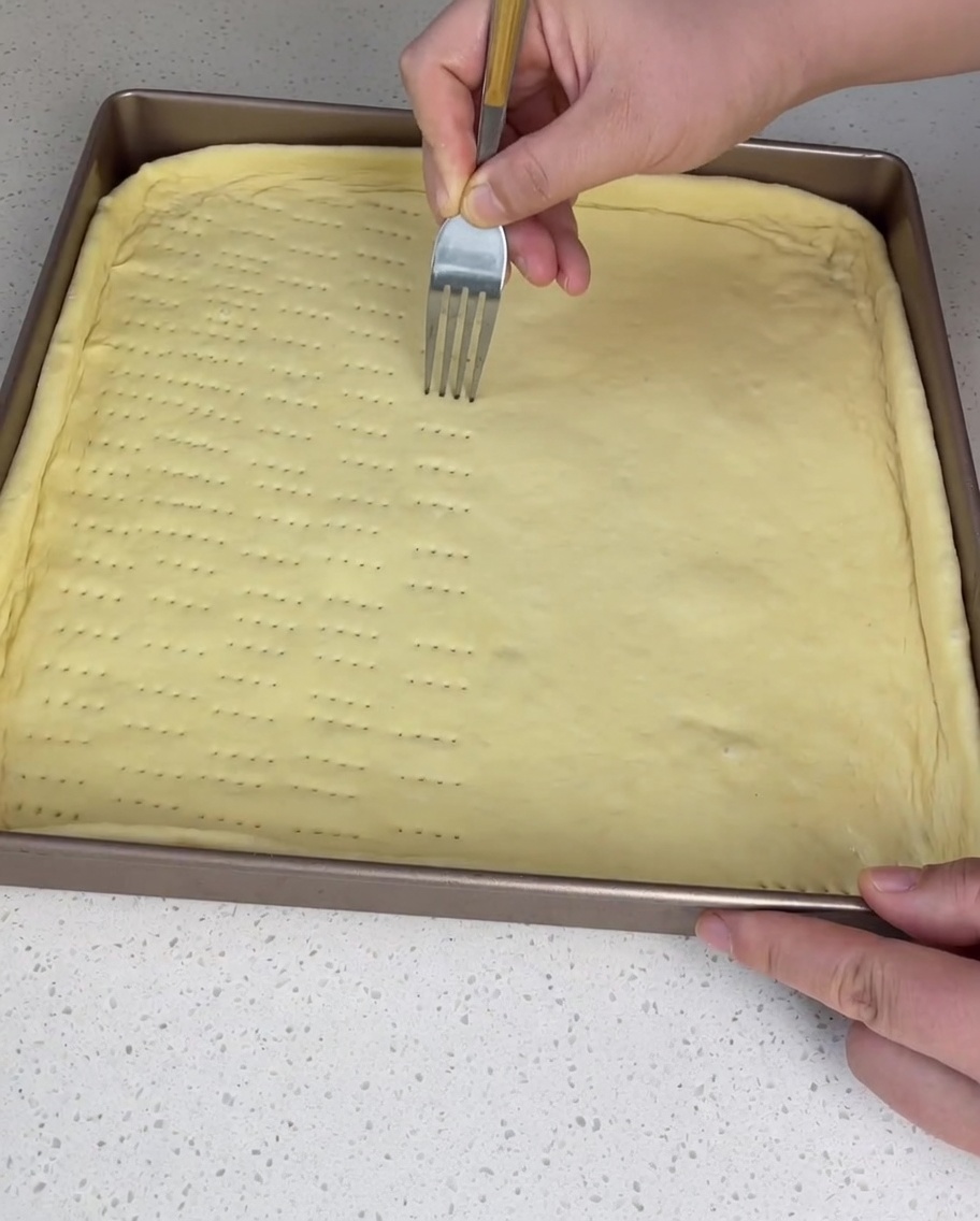 フォークを使って生地に穴を開ける様子。