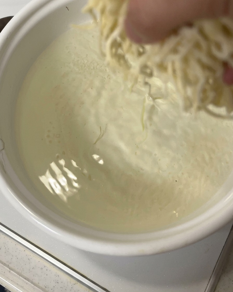 沸騰した鍋にラーメンの麺を入れている様子。