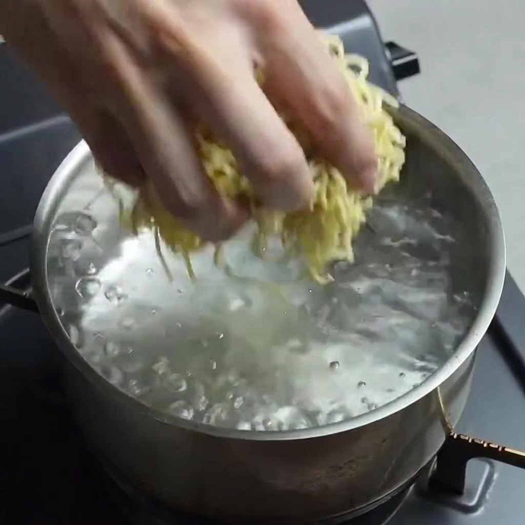 沸騰したお湯に生ラーメン麺を入れている様子。
