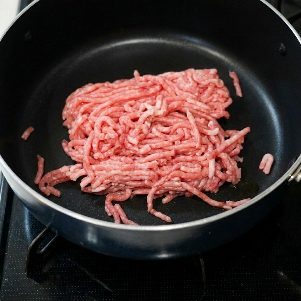 フライパンで豚ひき肉を豆板醤とにんにくペーストと一緒に炒めている様子。