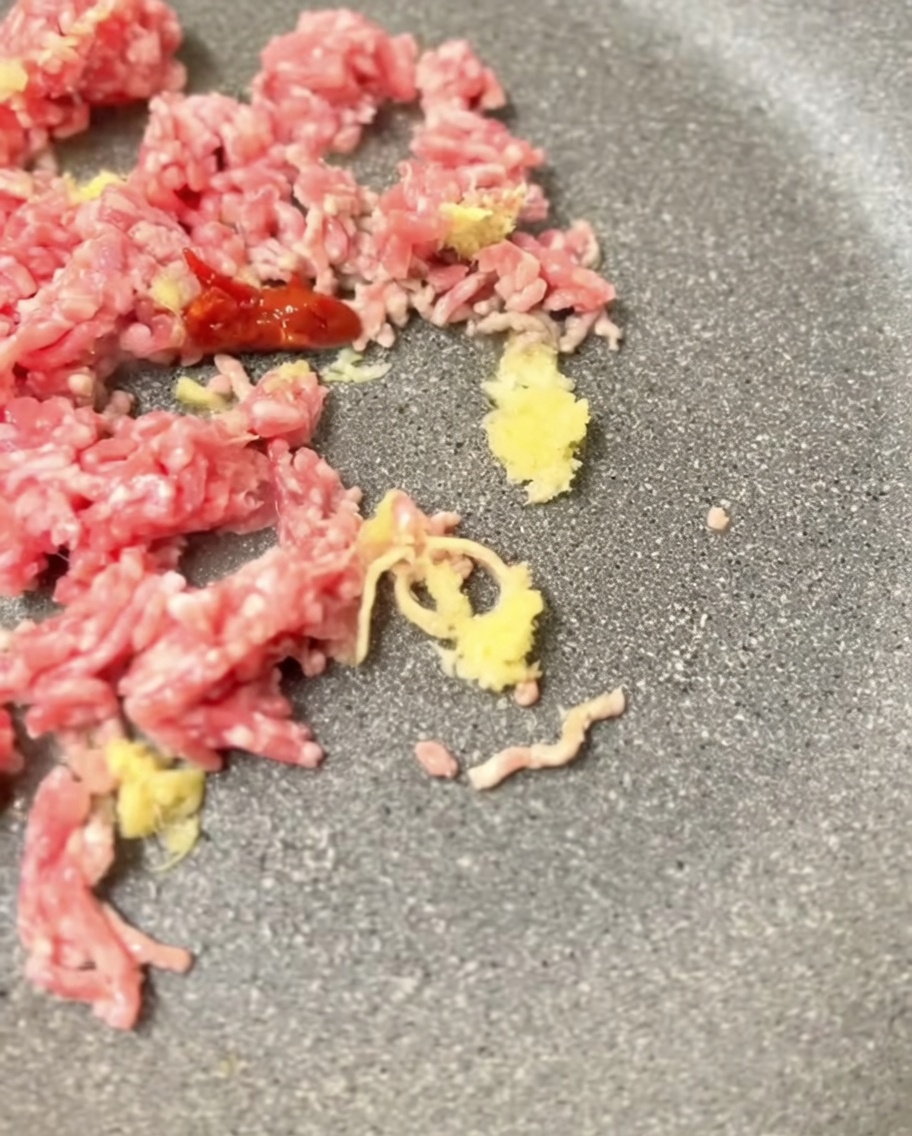 炒めた肉に味噌を加えて馴染ませている様子。