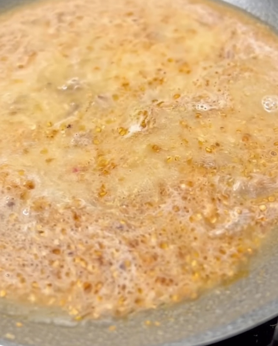 煮立っているスープに牛乳を加えて混ぜている様子。