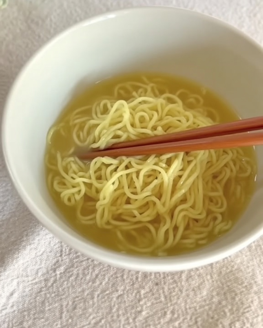 器に盛った麺に熱々のスープを注いでいる様子。