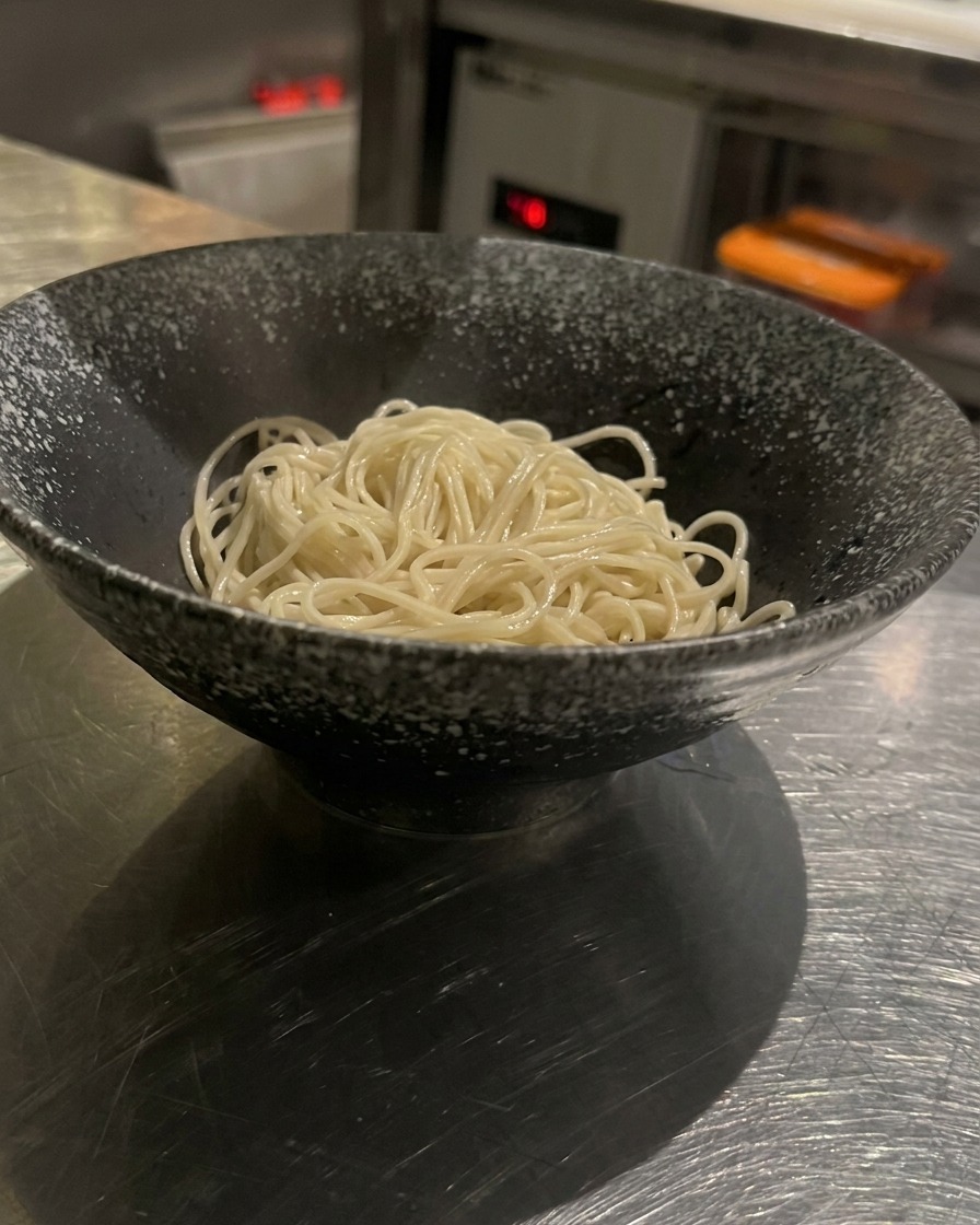 器に入れた麺に熱々のスープを注いでいる様子。