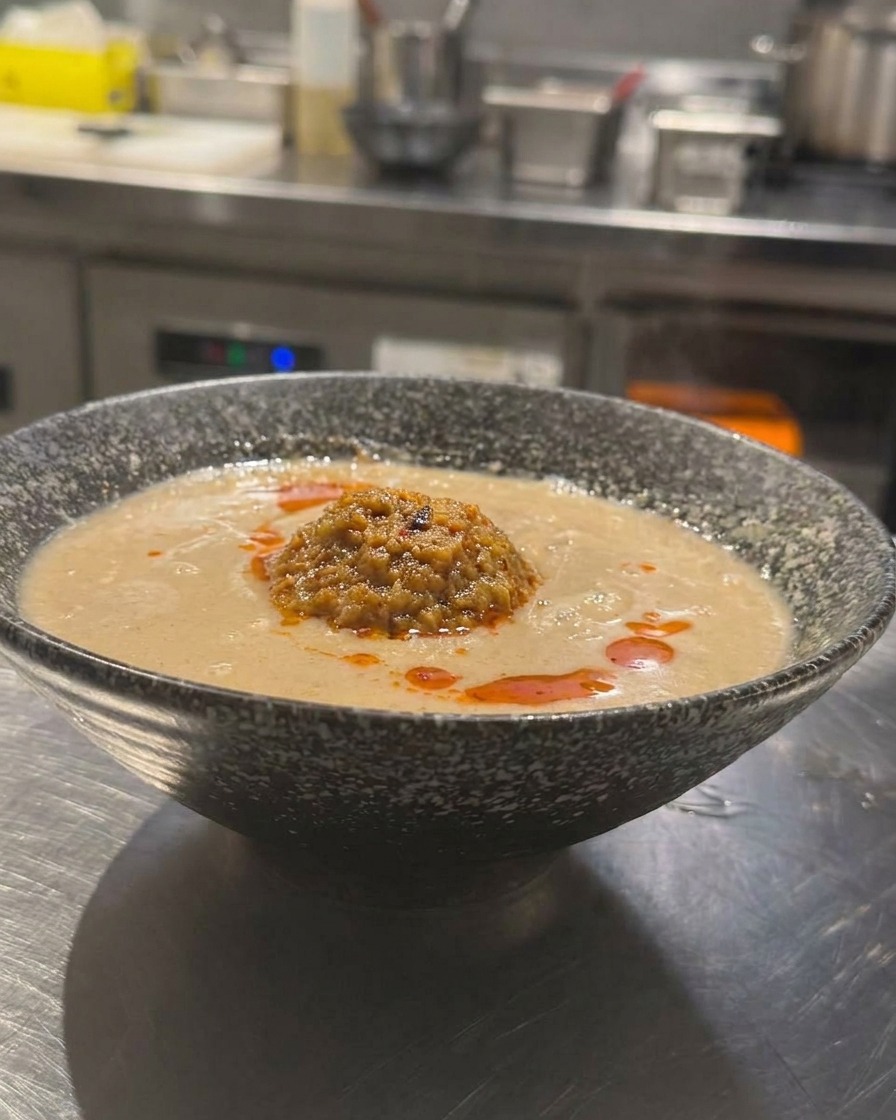 担々麺にラー油をかけている様子。