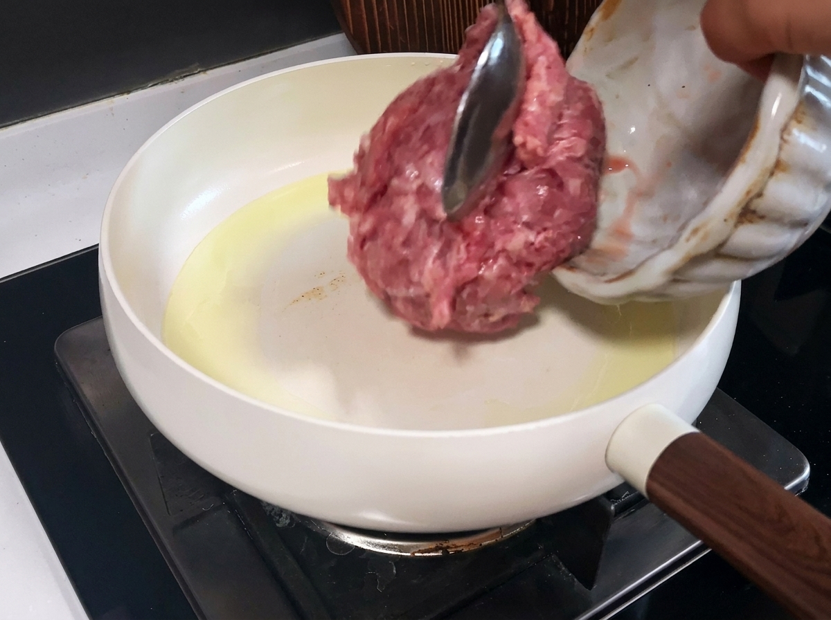 白いフライパンでこんがりと炒められている豚ひき肉。