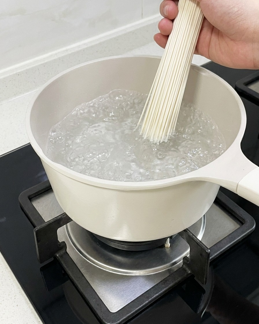 鍋の熱湯で茹でられているラーメンの麺。
