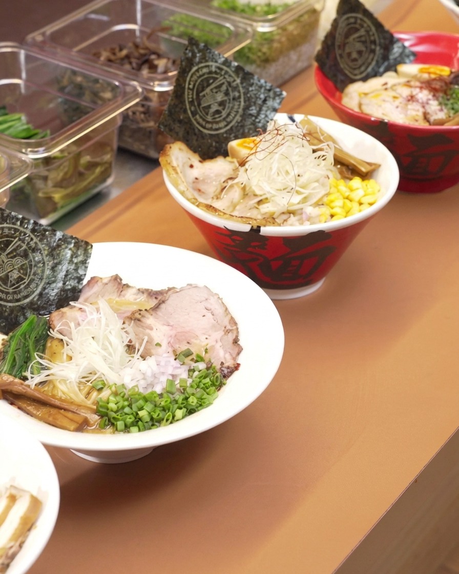 骨が入った大きな寸胴鍋に、ピッチャーから綺麗な水を注いでいる様子。