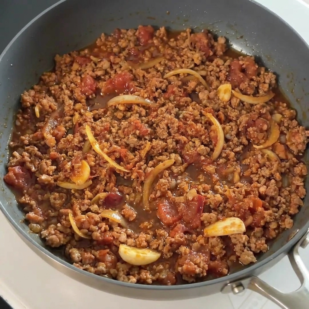 味付けされた豚肉に醤油を回し入れている様子