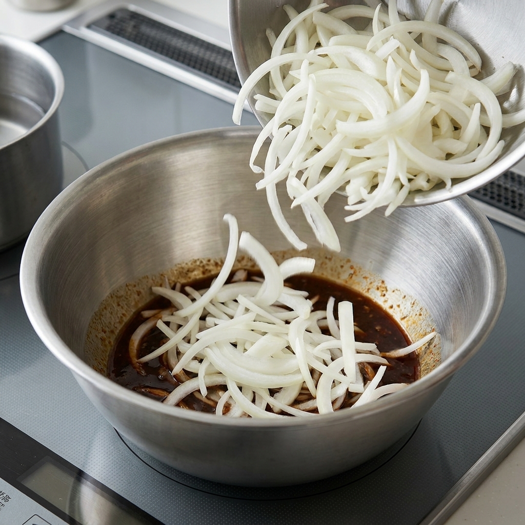 茹で上がった麺をソースと和えている様子