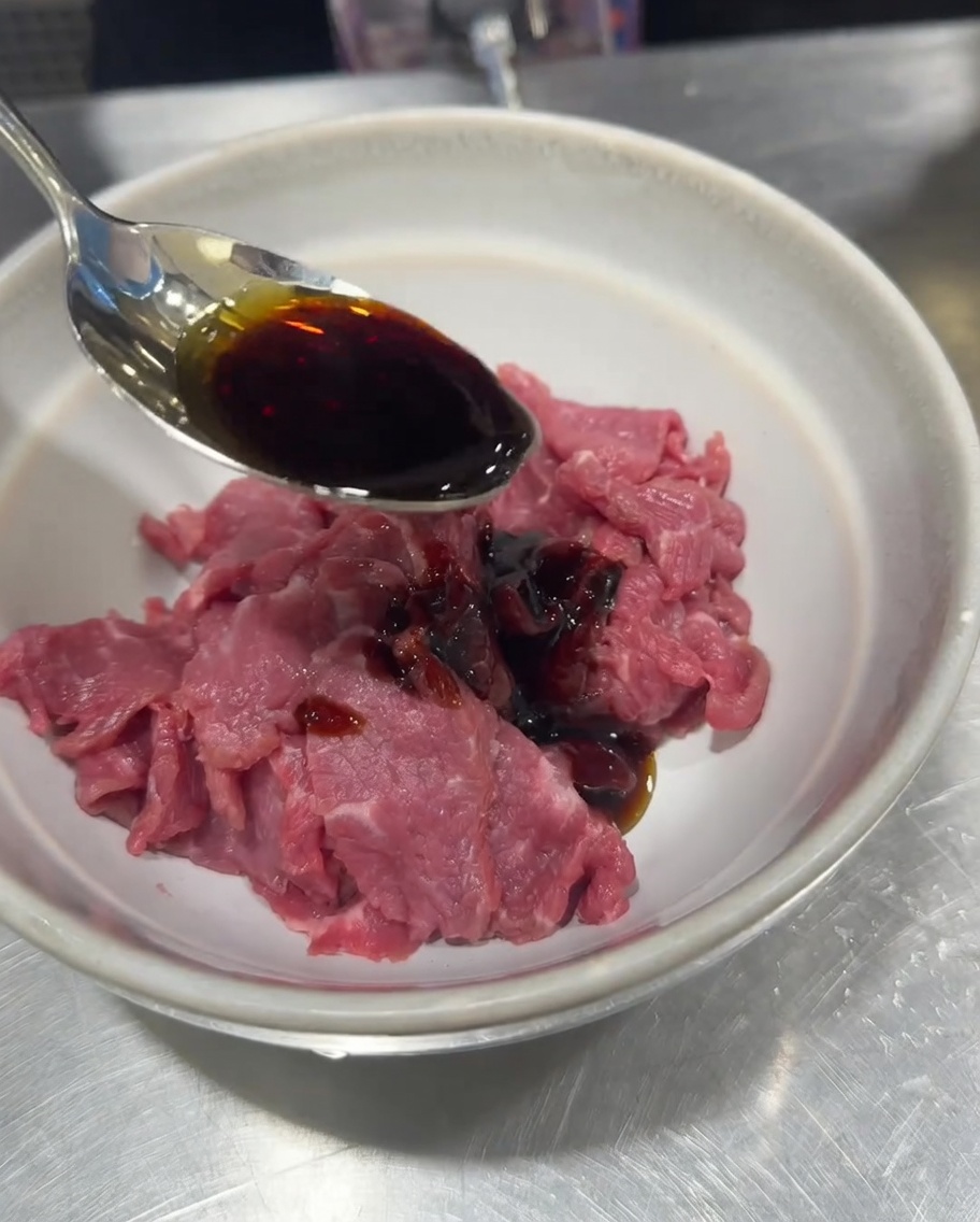 ボウルに入れた生肉に醤油、塩、こしょう、コーンスターチで下味をつけているところ。