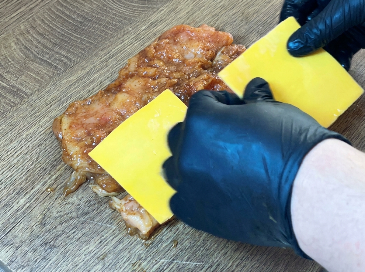 鶏肉の中央にスライスチーズをのせている様子。