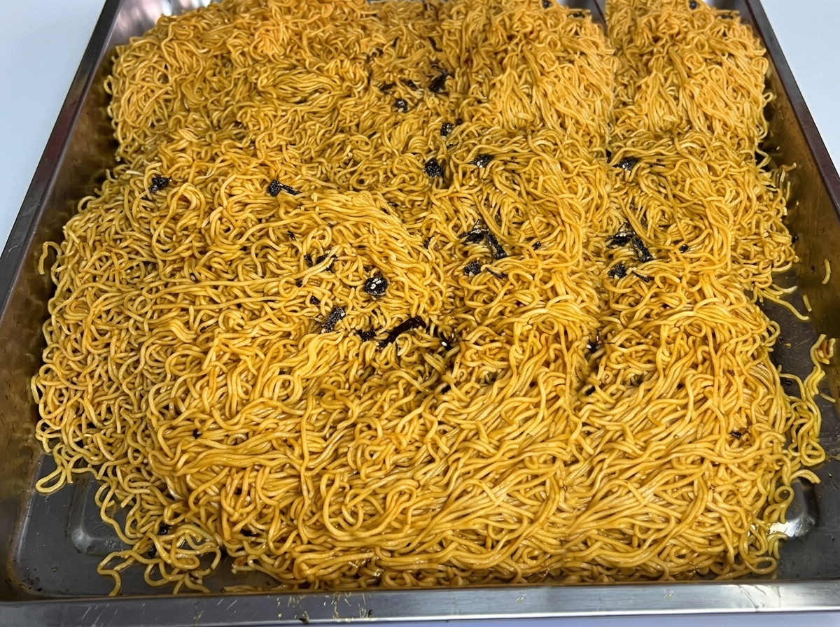 大きなステンレスのトレイに広げられた茹で上がった麺。