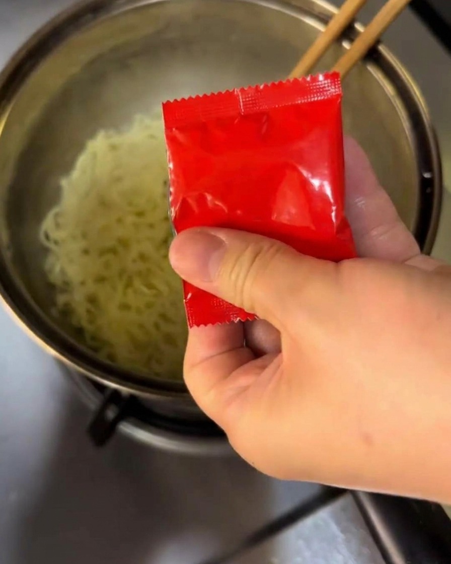 茹で上がった麺にソースを混ぜている様子。