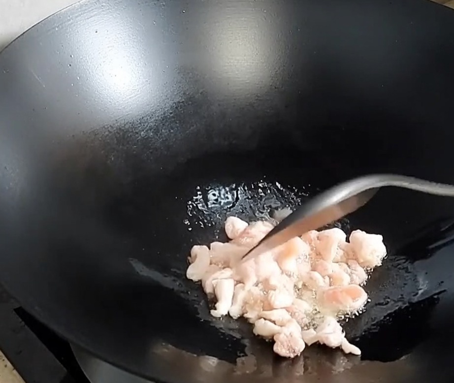 中華鍋で豚バラ肉を炒め、脂が出ている様子。