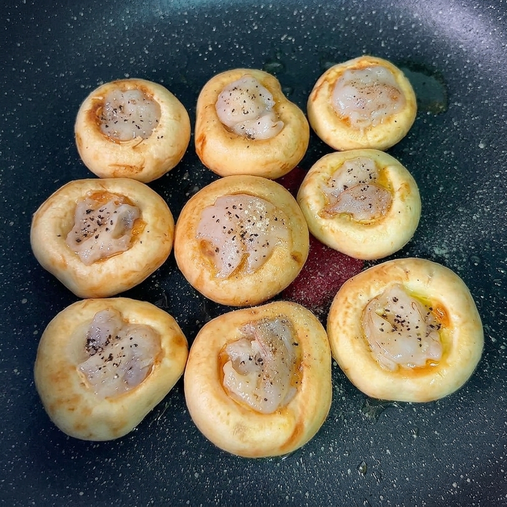 海老の表面に仕上げの味付けをされた調理済みマッシュルーム。